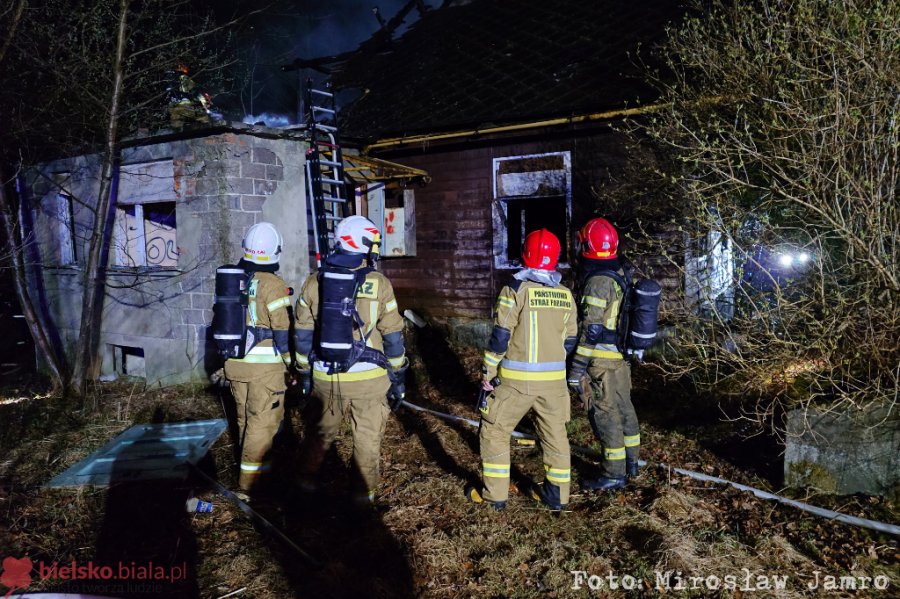 Drewniany budynek w ogniu. Słup dymu widoczny z daleka - foto
