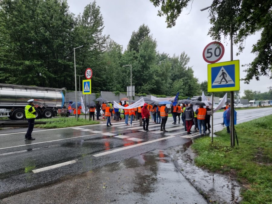 Mimo opadów protest na DK1 trwa. Kolejarze z transparentami chodzą po przejściu - foto